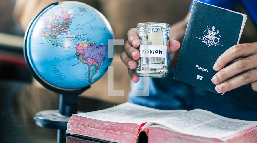 Savings jars full of money with passport and bible for mission, christian concept