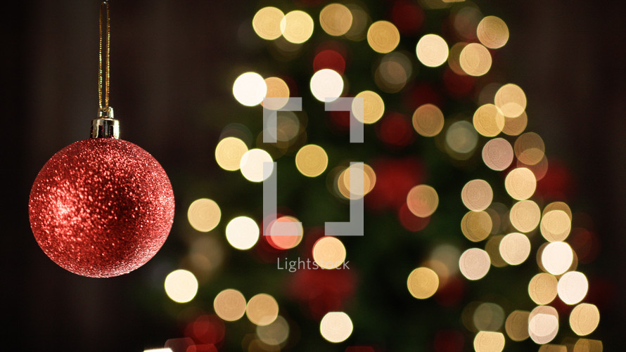 Christmas ball decoration with blurred Christmas tree on the background