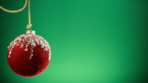 Red Christmas ball with green background