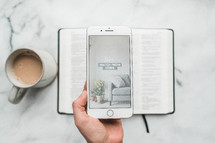 overhead view, coffee mug, smartphone, opened Bible, and notebook on a table