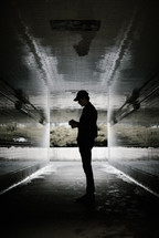 a man standing in an urban tunnel 