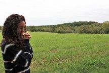 young woman praying outdoors 