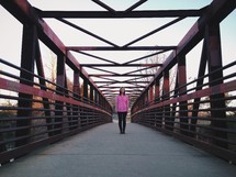woman standing on a walking bridge 