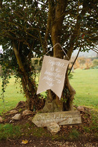 together is a beautiful place to be sign hanging on a tree for a wedding 