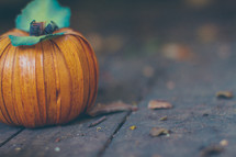 a woven pumpkin on a wood deck 