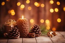 Candlelight and pine cones on wooden table