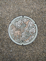 deer on a sewer manhole cover 