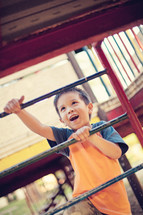 a boy child climbing on a playground 