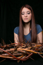 girl holding a crown of thorns 