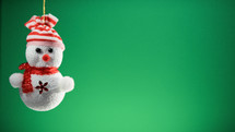 Tiny snowman decoration for Christmas with green background