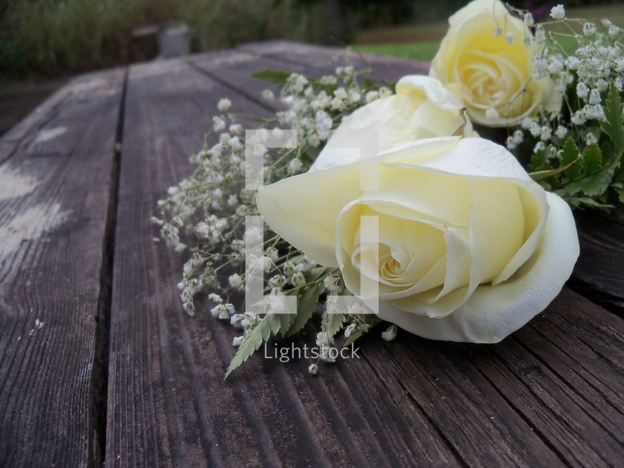 A bouquet of white roses sits on a table top making someones day on their wedding day, anniversary or special celebration.