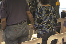 couple holding hands at a worship service 