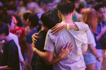 young men hugging at a worship service 