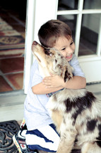 child hugging a dog