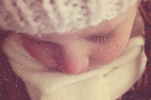 face of a girl child in falling snow 
