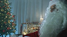 Santa Claus under Christmas Tree at home