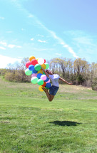 woman jumping up holding balloons 