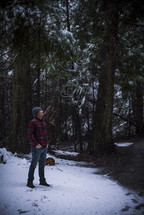 a man standing in a winter forest catching snowflakes on his tongue 