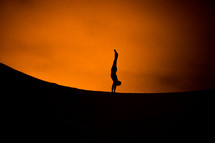 silhouette of a man doing a handstand 