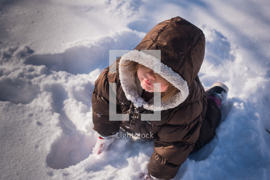 a toddler girl playing in snow 