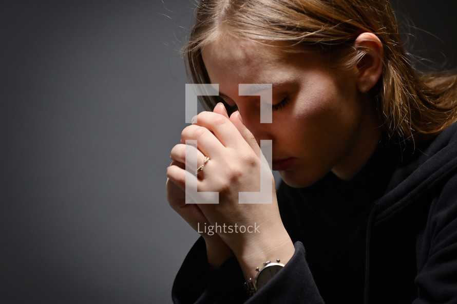 Young Woman Hands Praying In the Dark