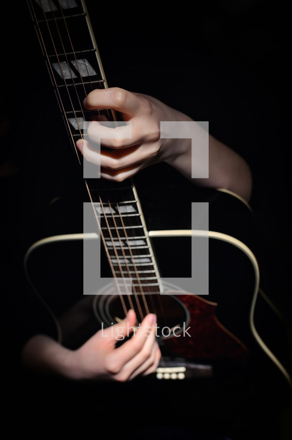 Young Woman Hugging With Her Hands Guitar, Isolated On Black