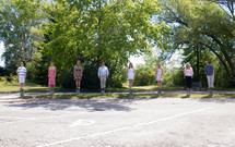 Family standing on posts in a parking lot.