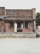 woman standing at an old saloon