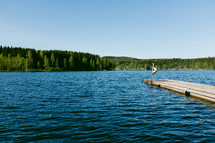 a man doing a flip off a pier into a lake 