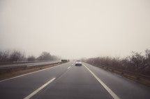car driving on a road on a foggy morning 