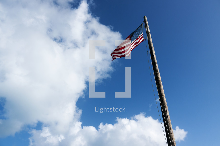 American flag on a flagpole in a blue sky 