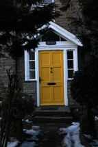 A stone house with a yellow door.