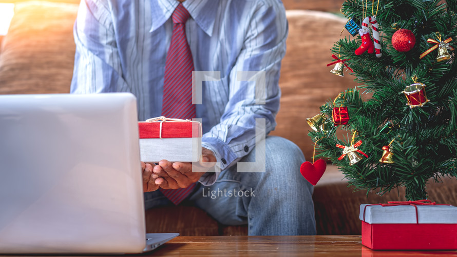 man praying looking at a computer screen for a online Christmas worship service 