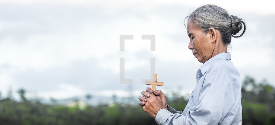 a woman holding a cross praying 