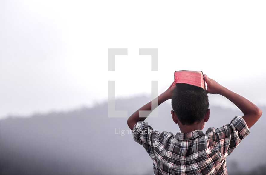 A Boy with a Bible on his head.