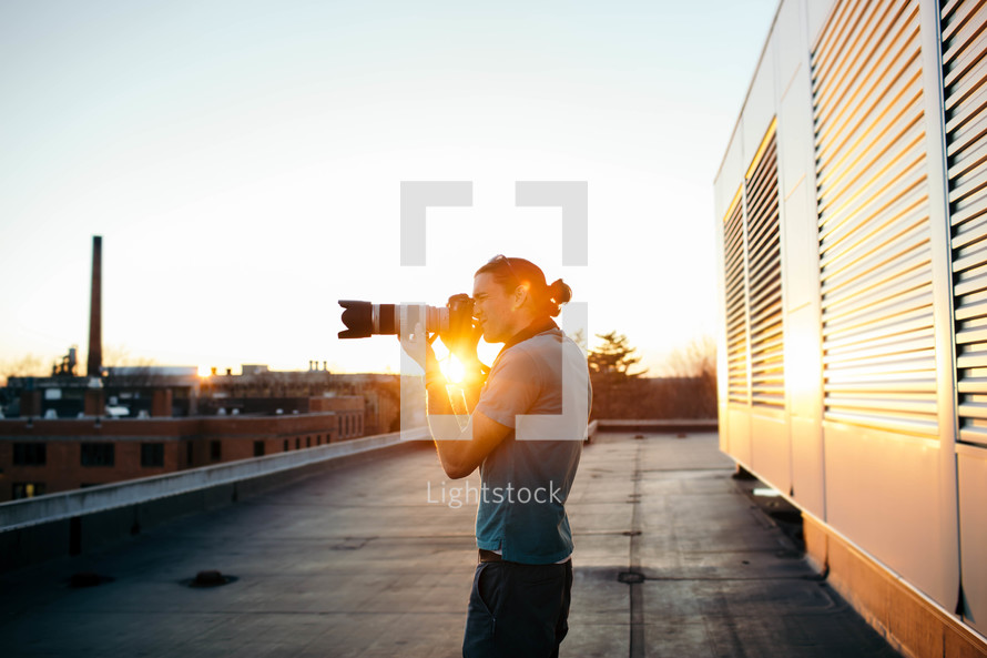 a man taking a picture with a camera with a long lens 