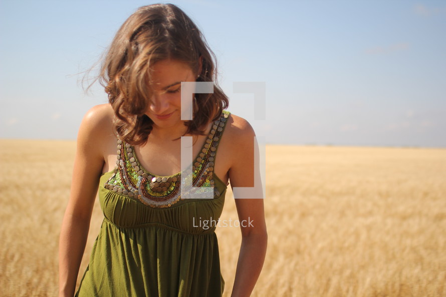 a woman standing in a field of golden grains