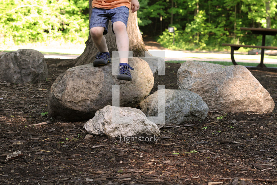 toddler boy standing on rocks 