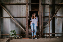 a young woman standing in a barn 