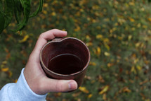 child holding a mug of apple cider 