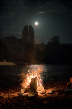 Bonfire by full-moon reflected on the river