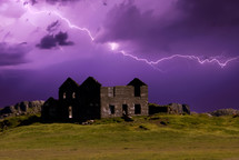 lightning in a purple sky over and abandoned house in ruins 