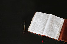 open Bible and pen on a table 