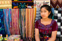a woman selling blankets in a market 