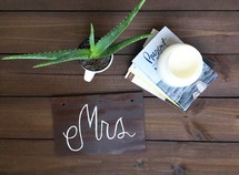 potted aloe plant, books, candle, and Mrs sign 