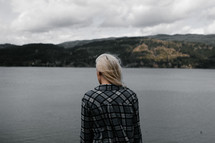 a woman looking out at a lake 
