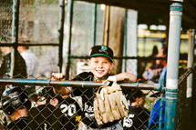 kids in a dugout at a baseball game 