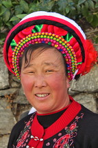 Smiling woman in a traditional hat from a minority tribe in China