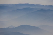 Low clouds cloak misty mountains in the early morning light over central China.