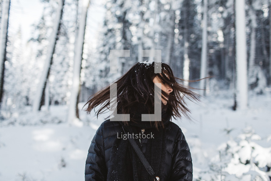 a woman standing in falling snow 